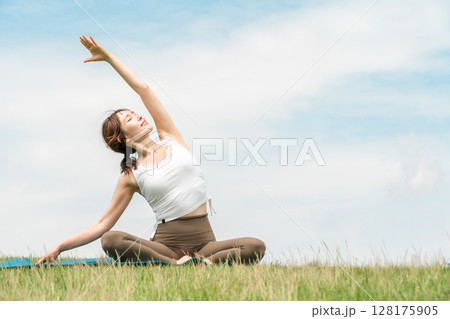 公園でヨガ・ヨガ教室・ピラティスをするヨガ講師の女性 公園でヨガ・ヨガ教室・ピラティスをするヨガ講師の女性 128175905