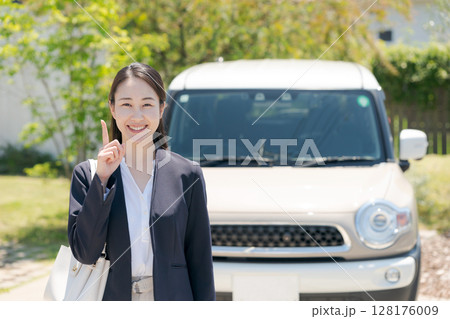 車の前に立つビジネスウーマン 128176009
