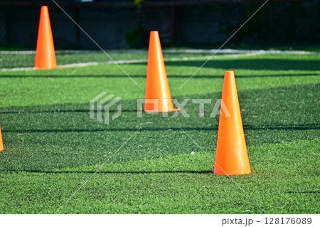 artificial green grass soccer field with orange training cones artificial green grass soccer field with orange training cones 128176089