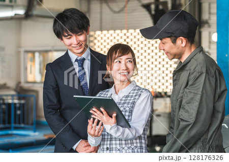 整備工場のピットにいる従業員の男女(自動車整備工場・民間車検場・スタッフ) 整備工場のピットにいる従業員の男女(自動車整備工場・民間車検場・スタッフ) 128176326