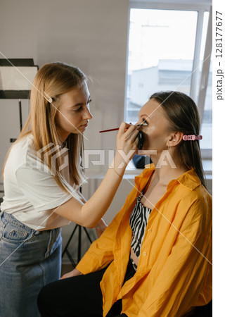 Makeup Artist Applying Foundation to Client in Salon 128177677