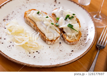 Sandwiches with salted herring fillet, pickled onions and scallions 128177697