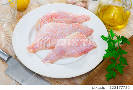 Raw chicken fillet on kitchen table Raw chicken fillet on kitchen table 128177726
