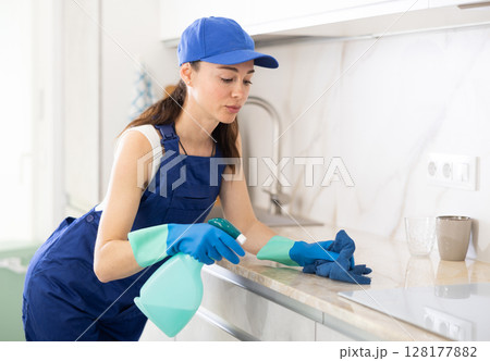 young positive girl is cleaning kitchen 128177882