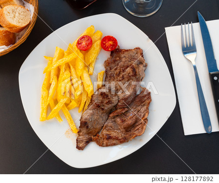 Baked beef fillet with fried potatoes and fresh tomatoes 128177892