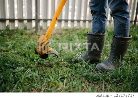 Gardening with a Hoe in Rubber Boots on Grass Gardening with a Hoe in Rubber Boots on Grass 128178717