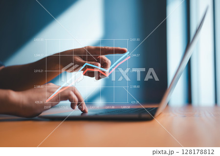 Businessman analyzing financial growth on virtual chart using laptop Businessman analyzing financial growth on virtual chart using laptop 128178812