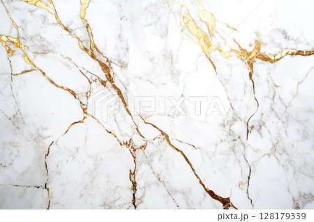 A luxurious white marble surface intricately veined with striking gold and subtle brown patterns, creating an elegant and opulent abstract background. 128179339