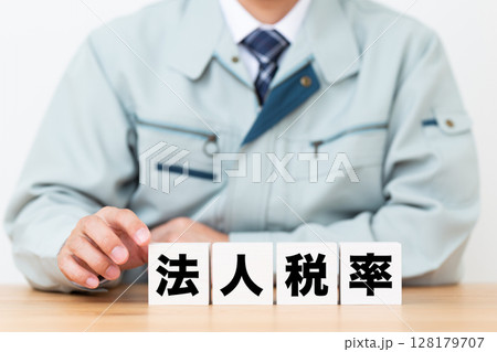 法人税率のブロックと作業着を着たミドル男性ビジネスマン 128179707
