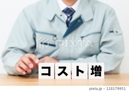 コスト増のブロックと作業着を着たミドル男性ビジネスマン 128179951