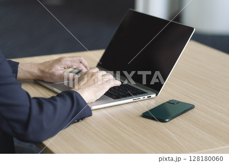 ノートパソコンで作業をする中高年男性の手元 ノートパソコンで作業をする中高年男性の手元 128180060