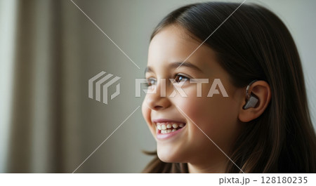 Happy young girl with a cochlear implant smiling, enjoying sound and technology Happy young girl with a cochlear implant smiling, enjoying sound and technology 128180235