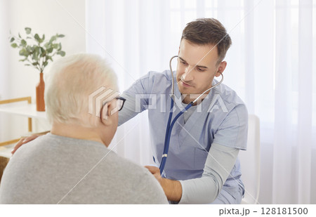 Young male physician doctor with stethoscope examining senior man's lungs, breathing and heartbeat Young male physician doctor with stethoscope examining senior man's lungs, breathing and heartbeat 128181500