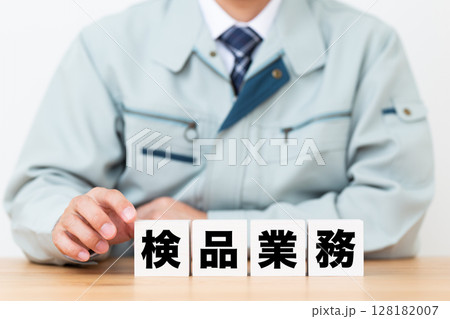 検品業務のブロックと作業着を着たミドル男性ビジネスマン 128182007