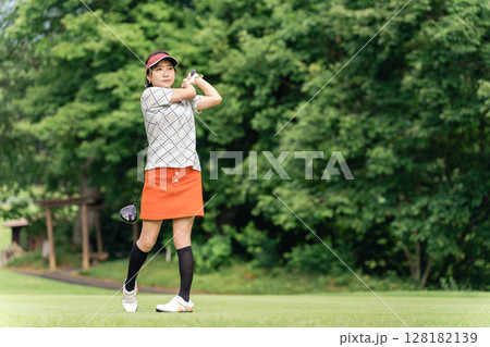 ゴルフ場でゴルフをするゴルファーの女性(笑顔・ティーショット・ゴルフコンペ) ゴルフ場でゴルフをするゴルファーの女性(笑顔・ティーショット・ゴルフコンペ) 128182139