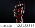 Photo of brunette woman with snake in red lingerie on dark background 128182838