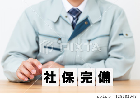 社保完備のブロックと作業着を着たミドル男性ビジネスマン 社保完備のブロックと作業着を着たミドル男性ビジネスマン 128182948