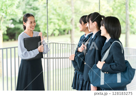 先生に挨拶する笑顔で校舎を歩く仲良しの女子学生(登校・下校・通学) 先生に挨拶する笑顔で校舎を歩く仲良しの女子学生(登校・下校・通学) 128183275