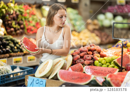 Woman near vegetable stand in store choose watermelon 128183578