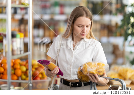 Young woman choosing pasta in grocery store Young woman choosing pasta in grocery store 128183581