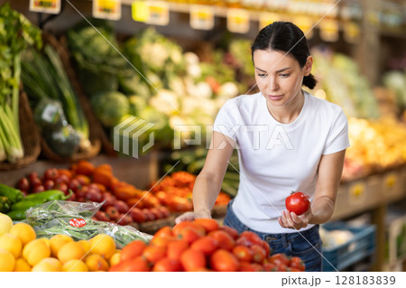 Young woman choosing red tomatoes 128183839