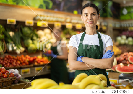 Portrait of female seller in interior of grocery supermarket Portrait of female seller in interior of grocery supermarket 128184060