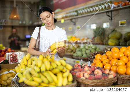Adult woman choosing bananas at vegetable shop 128184077