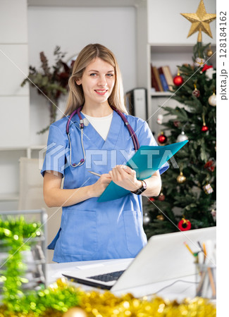 Nurse standing in office with clipboard during Christmas 128184162
