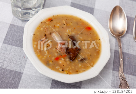 Hearty soup with mushroom, pork, vegetables and pearl barley 128184203