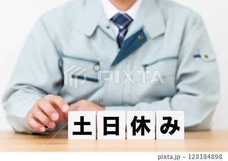 土日休みのブロックと作業着を着たミドル男性ビジネスマン 128184898