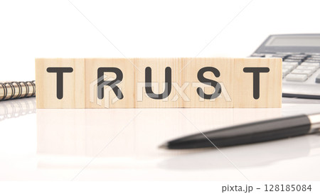 The concept word TRUST is assembled from wooden cubes. Investment based on trust concept 128185084
