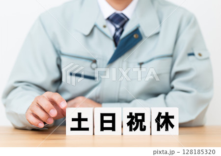 土日祝休みのブロックと作業着を着たミドル男性ビジネスマン 128185320