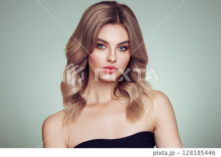 A beautiful young woman with shiny wavy blonde hair 128185446