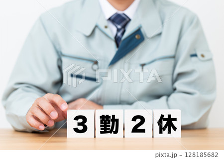 3勤2休のブロックと作業着を着たミドル男性ビジネスマン 128185682