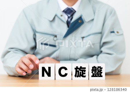 NC旋盤のブロックと作業着を着たミドル男性ビジネスマン 128186340