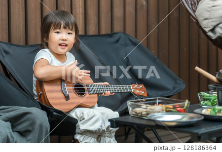 ギターを弾いてキャンプ,グランピング,別荘,民泊を楽しむ女の子,娘,子供 ギターを弾いてキャンプ,グランピング,別荘,民泊を楽しむ女の子,娘,子供 128186364