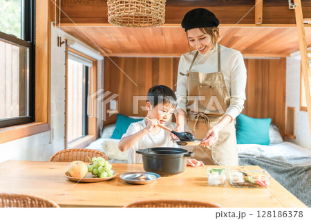 コテージでカレーの盛り付け,食事の支度,料理を親子で楽しむファミリー（家族旅行・グランピング） 128186378