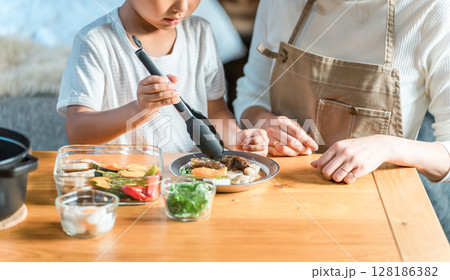 コテージでカレーの盛り付け,食事の支度,料理を親子で楽しむファミリー（家族旅行・グランピング） 128186382
