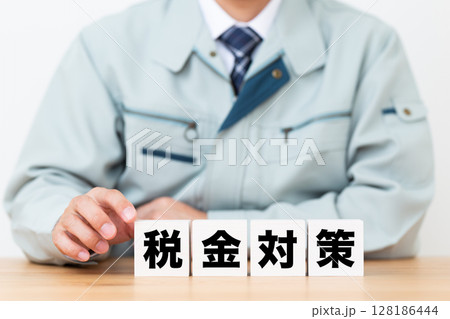 税金対策のブロックと作業着を着たミドル男性ビジネスマン 128186444