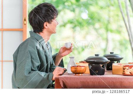 旅館で会席料理を楽しむ若いアジア人男性(部屋食・懐石料理・御膳・贅沢) 旅館で会席料理を楽しむ若いアジア人男性(部屋食・懐石料理・御膳・贅沢) 128186517