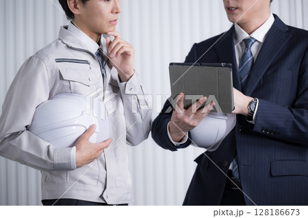 ゼネコンなどの現場で資料を確認する作業服とスーツの男性 打ち合わせで確認する ゼネコンなどの現場で資料を確認する作業服とスーツの男性 打ち合わせで確認する 128186673