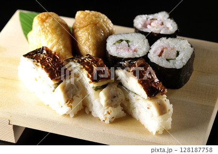 焼鯖、海苔巻、稲荷寿司を黒背景で撮影 128187758
