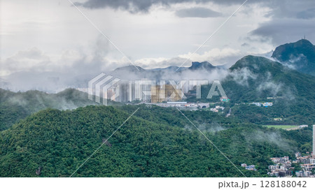 July 1 2025 View of a Foggy Cityscape Amid Green Hills and Moody Skies July 1 2025 View of a Foggy Cityscape Amid Green Hills and Moody Skies 128188042