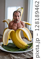 Surprised man's torso and head emerge from a peeled banana. Funny, unexpected. 128189462