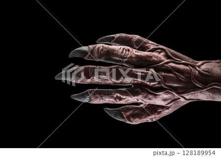 Red devil monster hand isolated on black background with clipping path 128189954