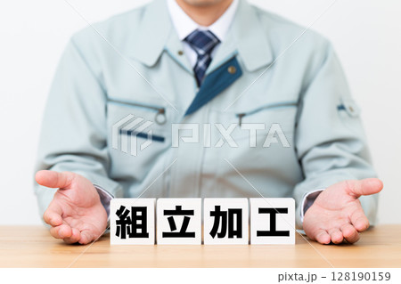組立加工のブロックと作業着を着たミドル男性ビジネスマン 128190159
