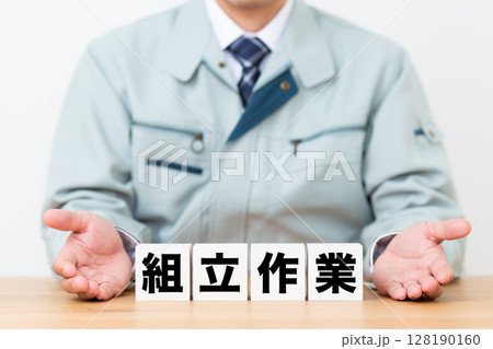 組立作業のブロックと作業着を着たミドル男性ビジネスマン 128190160