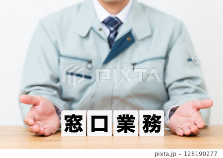 窓口業務のブロックと作業着を着たミドル男性ビジネスマン 128190277