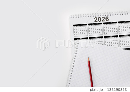 2026 calendar and blank spiral notebook with pencil for planning new year appointments, events, and personal goals for future 128190838
