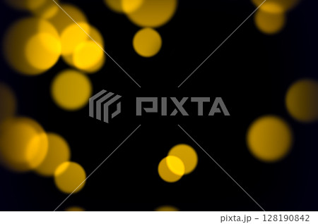 Glowing yellow soft bokeh lights on dark background for abstract elegant party ambiance romantic decoration or vintage style visuals 128190842